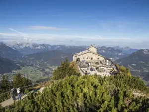 Das Kehlsteinhaus auf dem Grat, Besucher auf dem Weg, dahinter die Berge