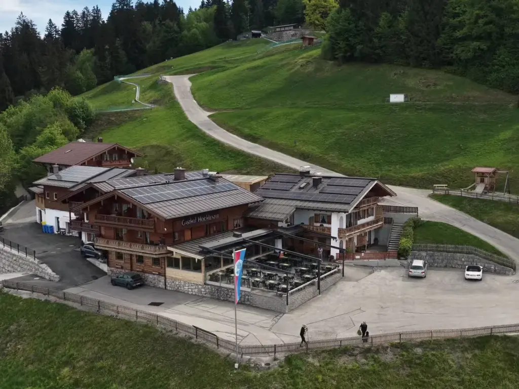 Alpengasthof Hochlenzer von oben mit Sonnenterrasse, Parkplatz und dem Weg zur Rodelbahn