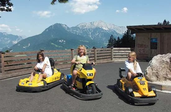 Kinder in gelben Tretcarts auf der Cart-Bahn