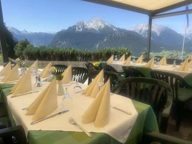 Gedeckte Tische auf der Terrasse des Hochlenzer, dahinter der Watzmann