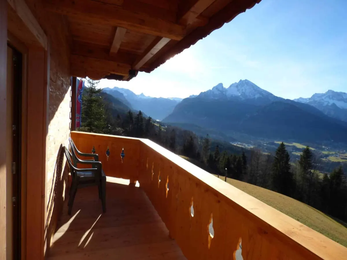 Holzbalkon eines Zimmers mit Blick über das Tal auf den Watzmann